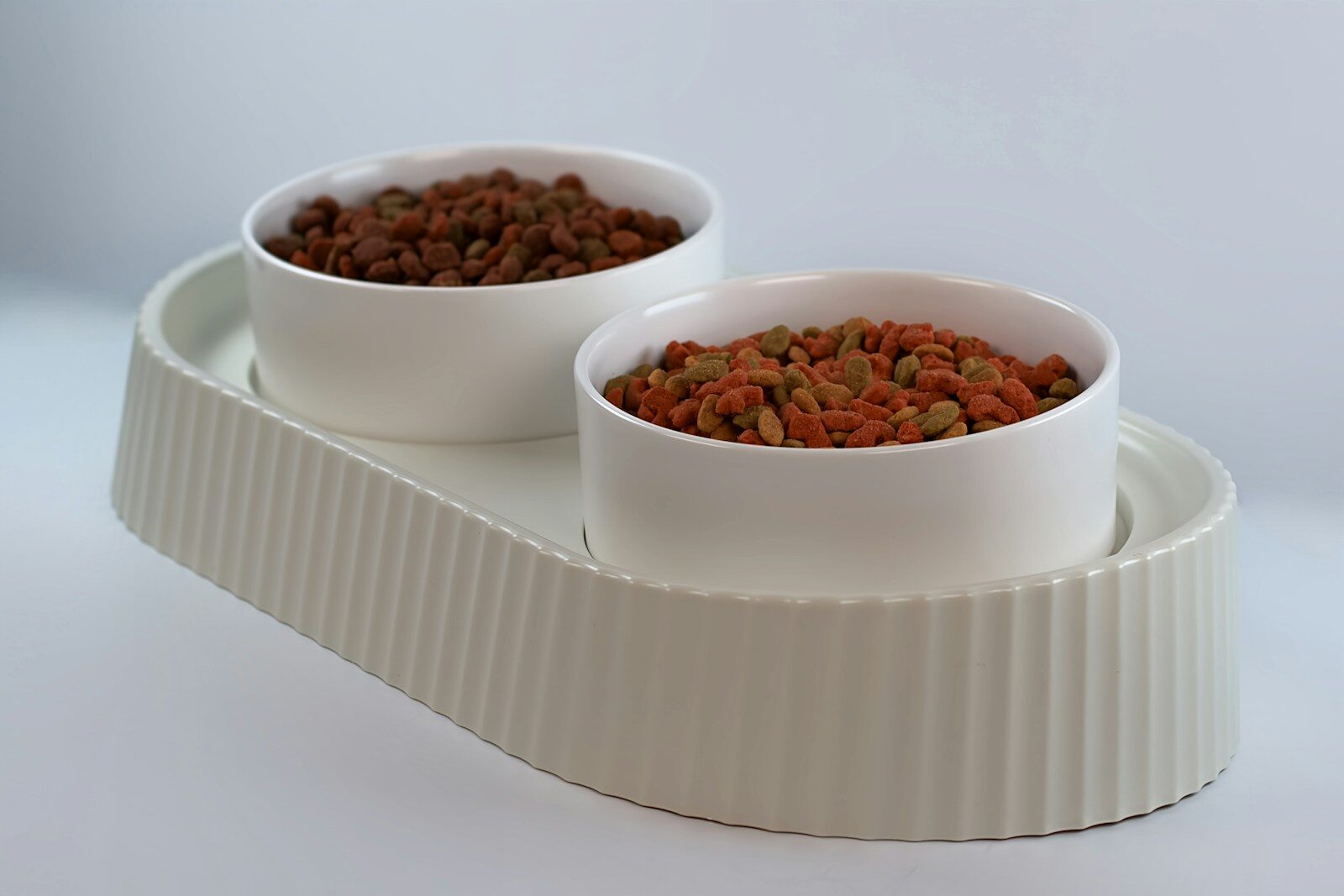 two bowls of food sit on a white tray